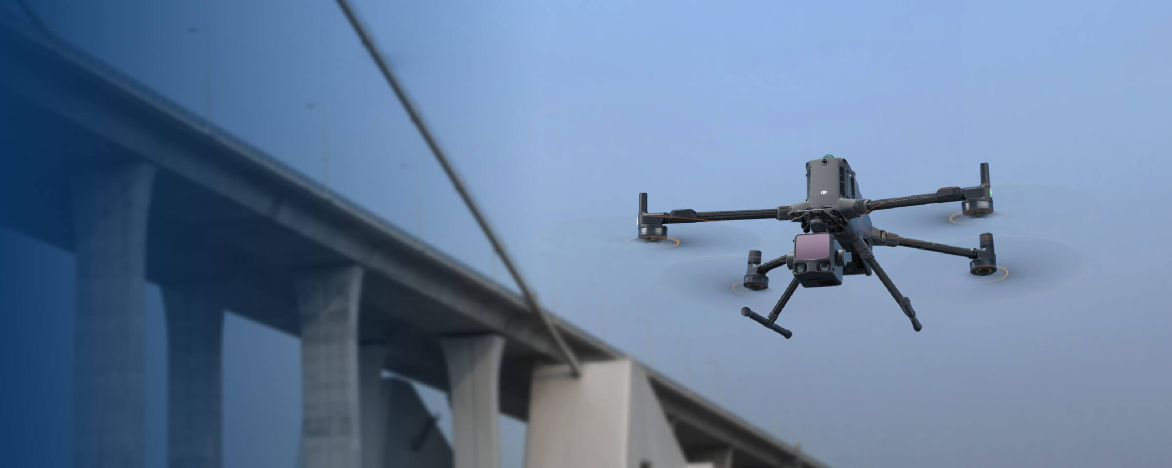 DJI enterprise drone carrying a survey payload beside a bridge