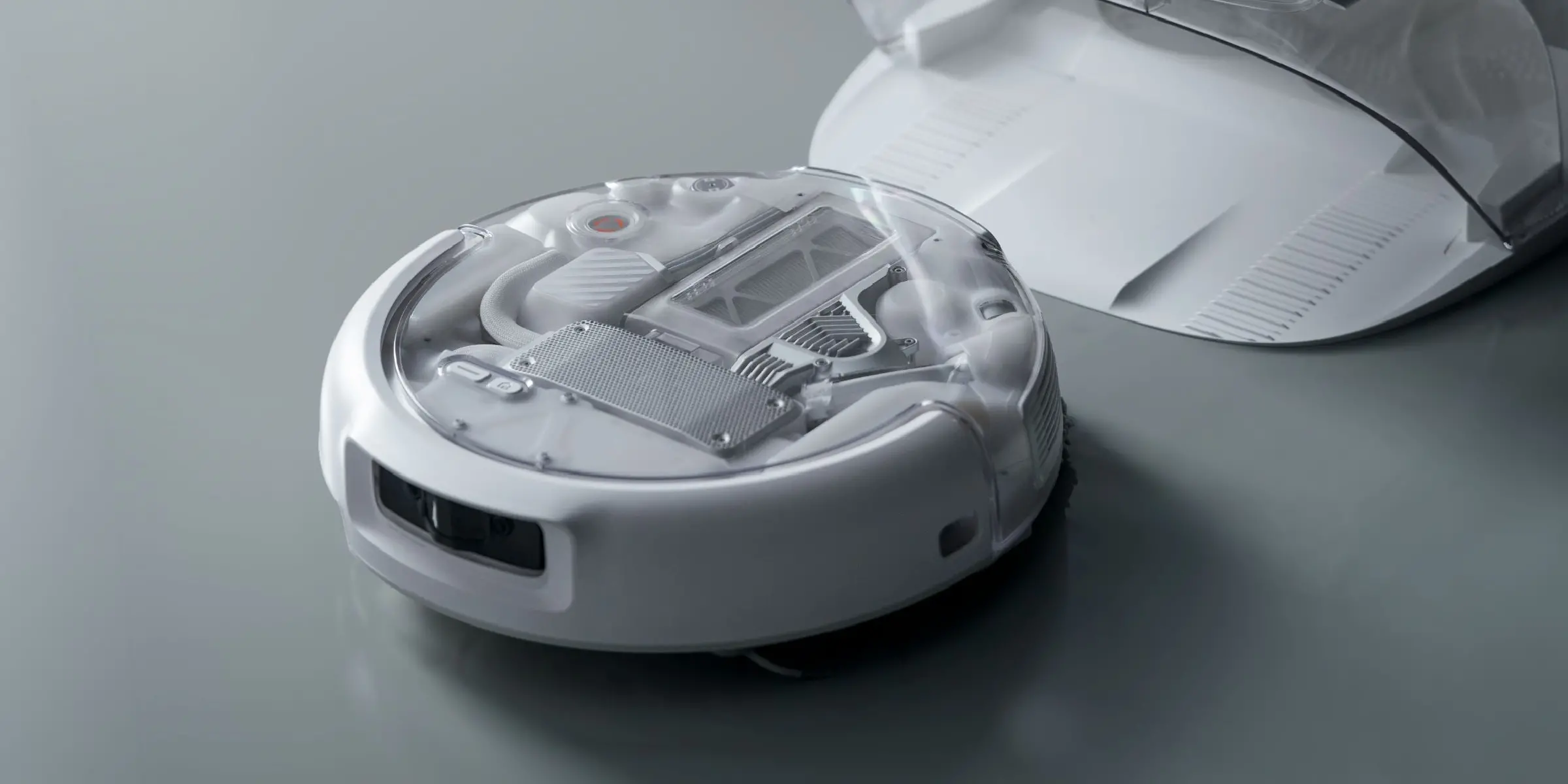 DJI ROMO A2 sprząta przy sofie w czasie odpoczynku domownika