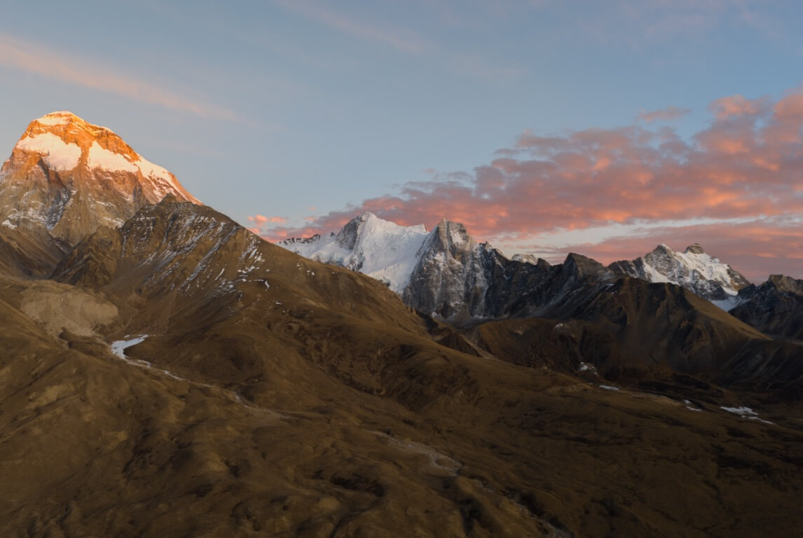 DJI promotional mountain landscape with warm light on snow-covered peaks