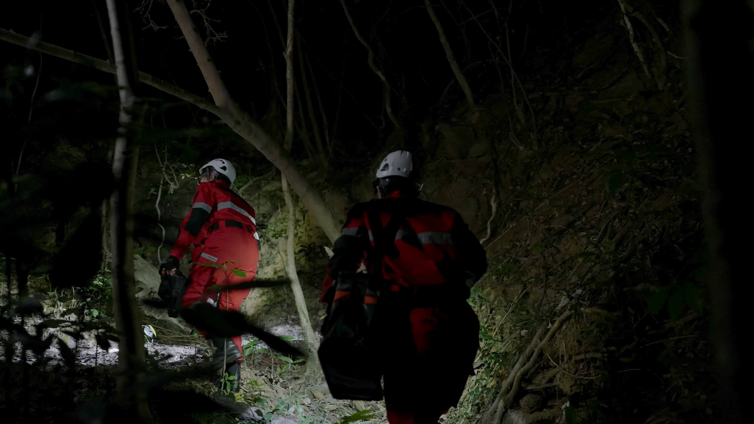 Rescue personnel with lights working outdoors at night in DJI promotional imagery